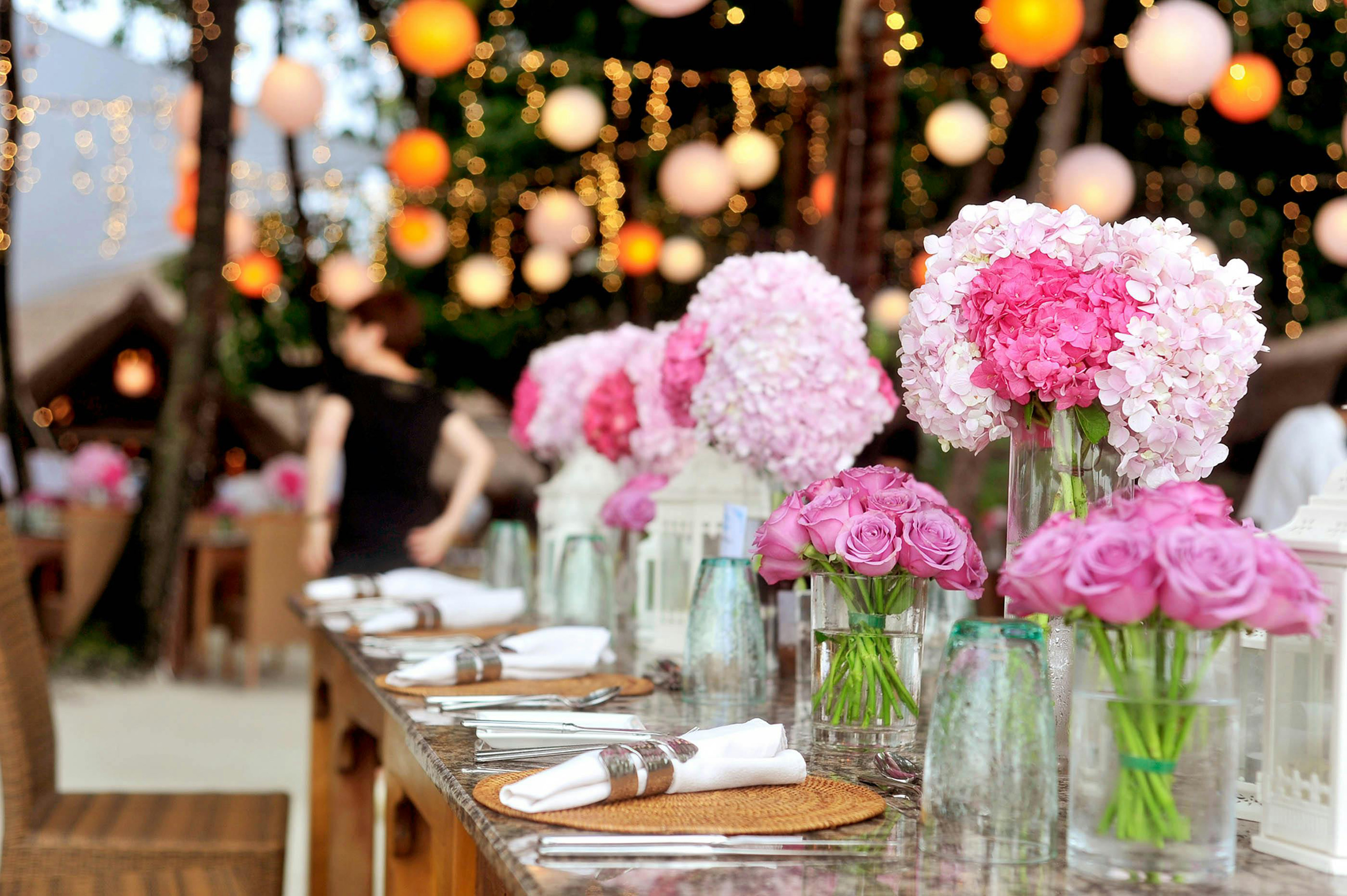 An event table set with glassware, cutlery, linen and flowers